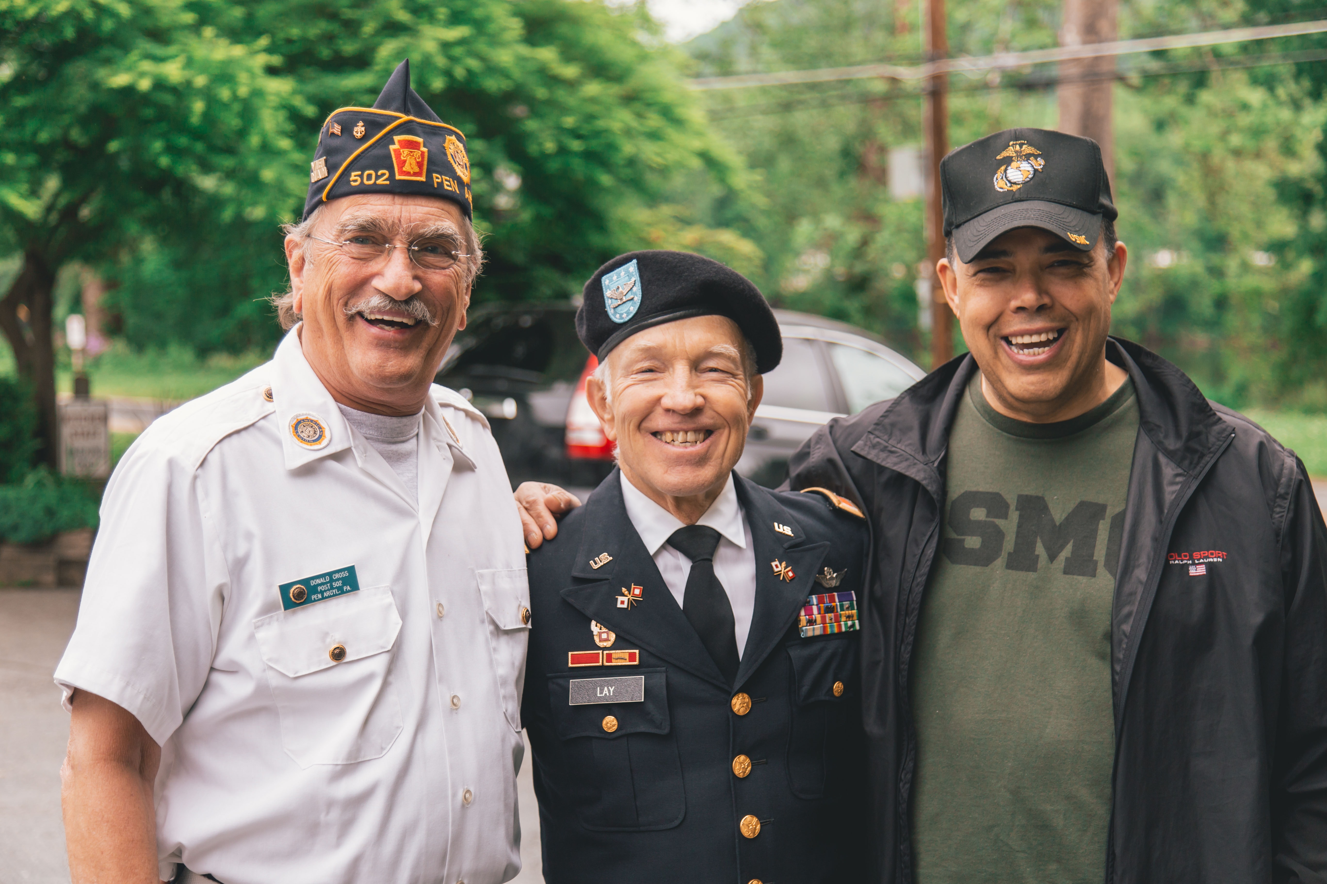 A picture of three US veterans with their arms over one another's shoulders.